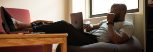 A man working on his laptop while sitting in a beanbag chair