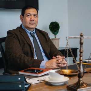 Man sitting at desk with scales of justice
