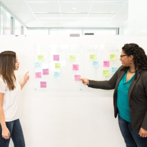 woman pointing at sticky notes on whiteboard