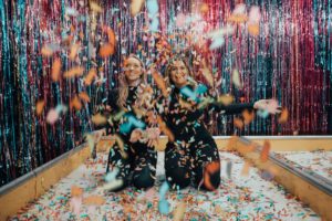 Two women celebrate with confetti