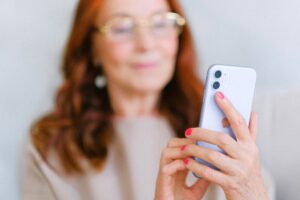 woman using an iPhone, the woman is out of focus, with the focus being on the iphone