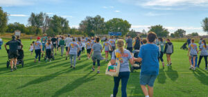 runners at the ffc8 5k across the field with branded shirts on