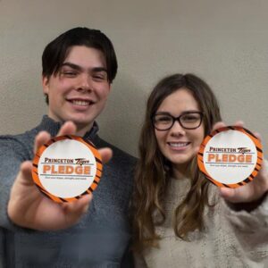 two students holding princeton tiger pledges