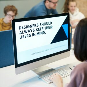 Computer with the words "Designers should always keep their users in mind" shown in a slide deck